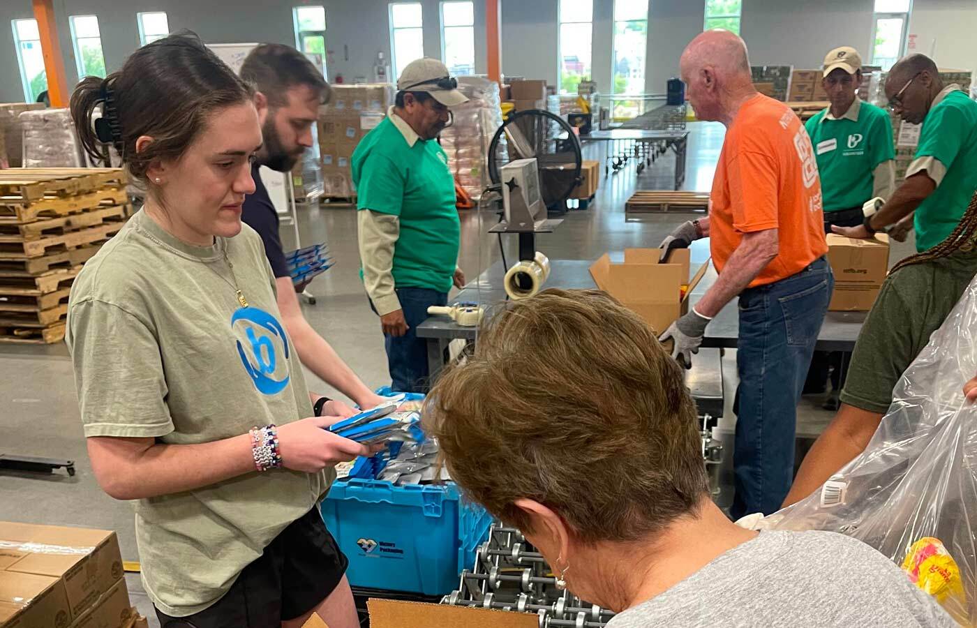 Many bizcom CARES employees working in a warehouse.